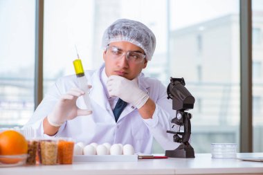 Besin uzmanı gıda ürünlerini laboratuarda test ediyor.