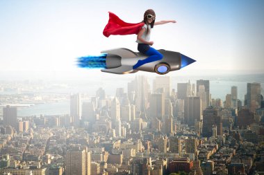 Süper kahraman kavramında küçük bir kız roket uçuruyor.