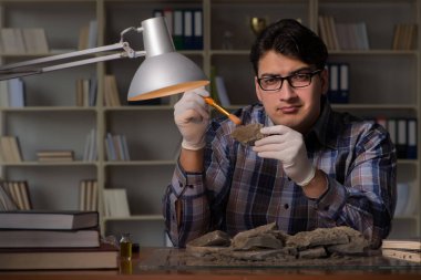 Arkeolog geç saatlere kadar ofiste çalışıyor.