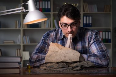 Arkeolog geç saatlere kadar ofiste çalışıyor.
