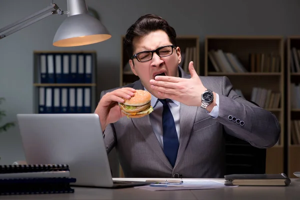 Empresario tarde en la noche comiendo una hamburguesa — Foto de Stock