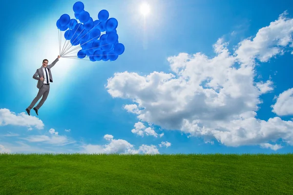 Affärsman flygande ballonger på ljusa dagen — Stockfoto