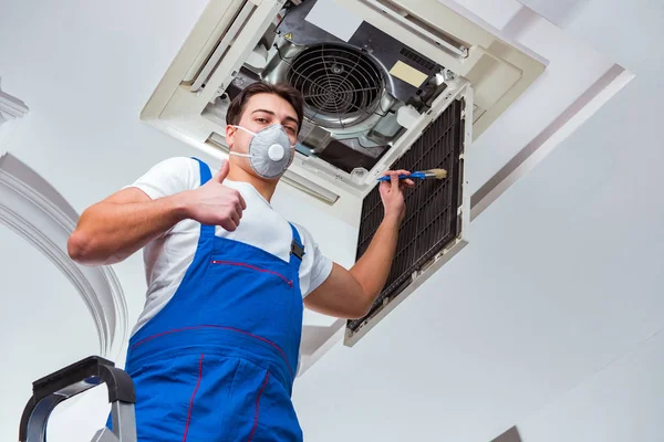 Worker repairing ceiling air conditioning unit — Stock Photo, Image