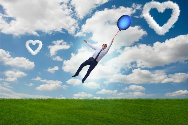 Чоловік літає повітряними кулями в романтичній концепції — стокове фото