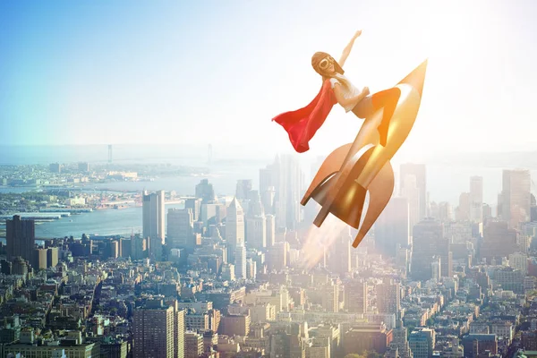 Little girl flying rocket in superhero concept — Stock Photo, Image