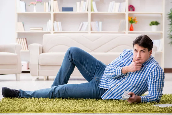 Jovem homem bonito sentado no chão em casa — Fotografia de Stock