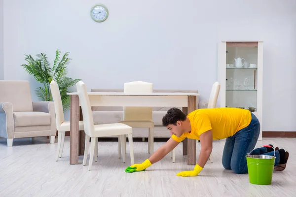 Jovem fazendo tarefas em casa — Fotografia de Stock