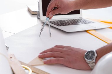 Erkek mühendis çizimler ve planlar üzerinde çalışıyor.