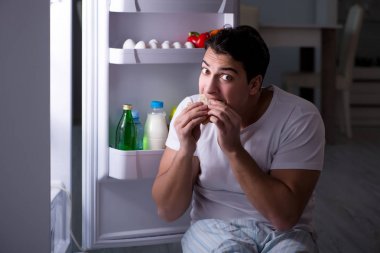 Buzdolabındaki adam gece yemek yiyor.