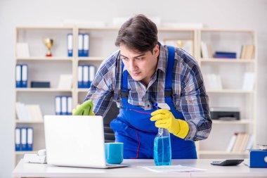 Temizlikçi ofisi temizliyor.