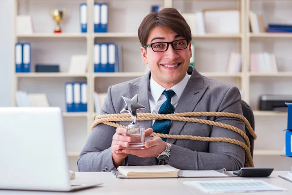 Businessman tied up with rope in office — Stock Photo, Image