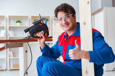 Genç marangoz ahşap kalaslarla çalışıyor.