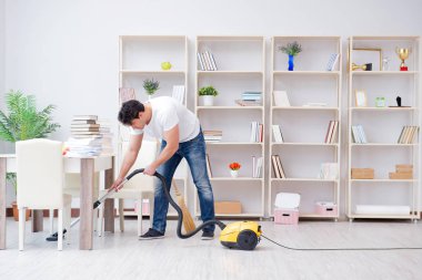 Adam evi temizliyor.