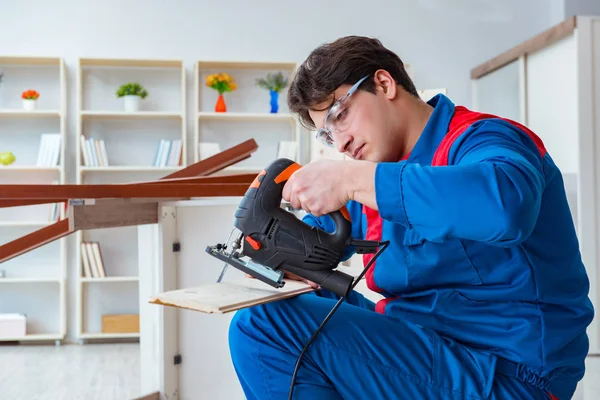 Genç marangoz ahşap kalaslarla çalışıyor.