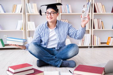 Genç öğrenci kitaplarla çalışıyor.