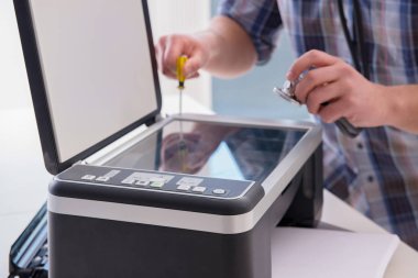 Tamirci bozuk renk yazıcısını tamir ediyor