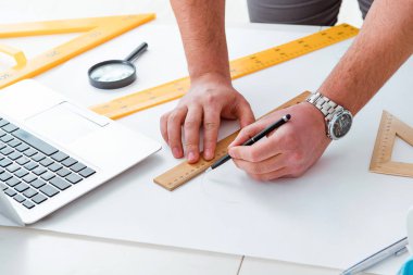 Erkek mühendis çizimler ve planlar üzerinde çalışıyor.