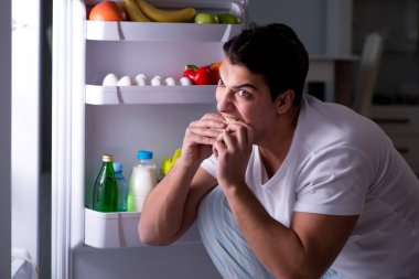 Buzdolabındaki adam gece yemek yiyor.