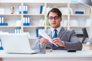 Ofisinde kağıt uçak olan bir iş adamı.