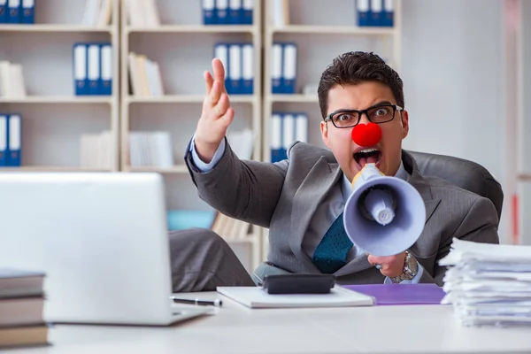 Homme d'affaires clown en colère dans le bureau avec un mégaphone — Photo