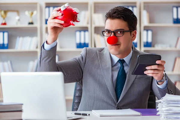 Empresário palhaço com banco porquinho fazendo contabilidade — Fotografia de Stock