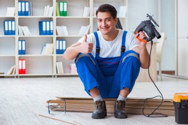 Zemin kaplamalarında çalışan genç bir işçi.