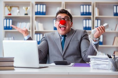 Ofiste çalışan palyaço işadamı.