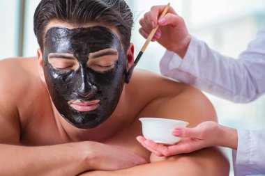 Kaplıca masaj konseptinde yakışıklı bir adam.