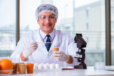 Besin uzmanı gıda ürünlerini laboratuarda test ediyor.