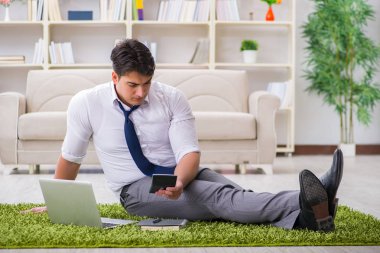 İş adamı ofiste yerde oturuyor.