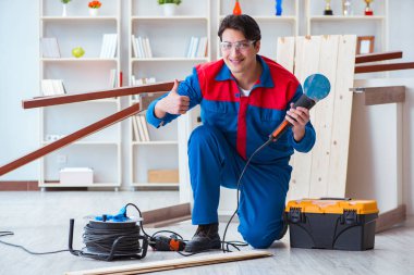 Genç marangoz ahşap kalaslarla çalışıyor.