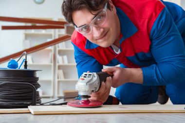 Genç marangoz ahşap kalaslarla çalışıyor.