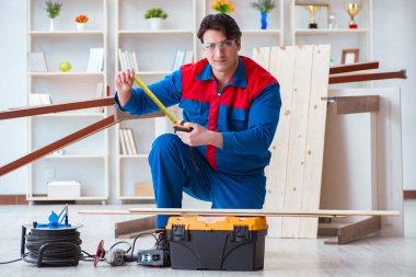 Genç marangoz ahşap kalaslarla çalışıyor.