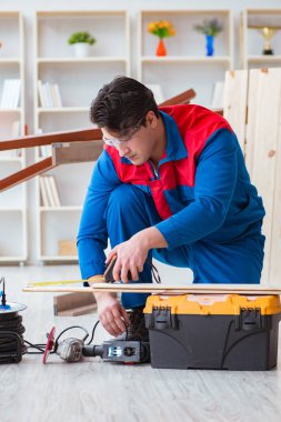 Genç marangoz ahşap kalaslarla çalışıyor.