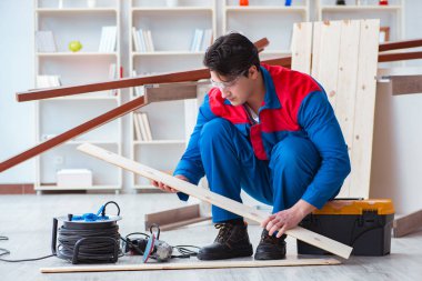 Genç marangoz ahşap kalaslarla çalışıyor.