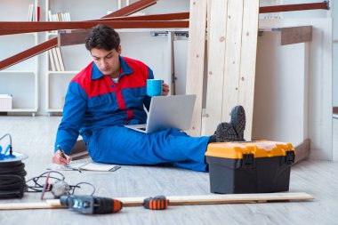 Dizüstü bilgisayarı olan genç bir marangoz