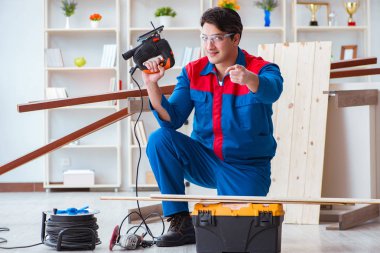 Genç marangoz ahşap kalaslarla çalışıyor.