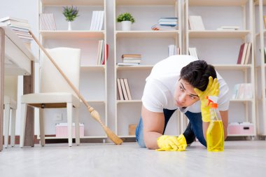 Adam evi temizliyor.