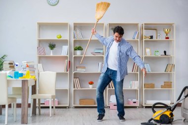 Adam evi temizliyor.