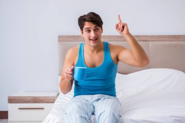 Genç adam yatakta uyanıyor.