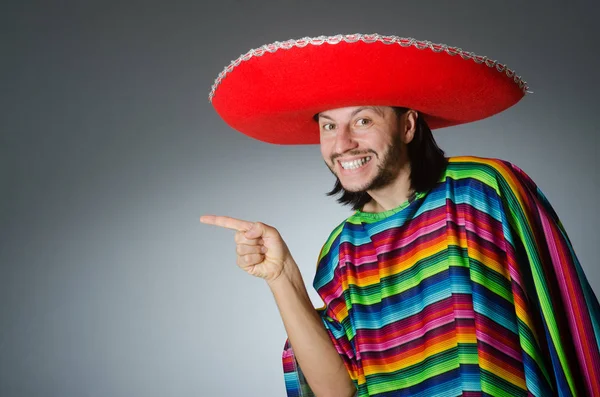 Hombre en un vívido poncho mexicano fondo gris aislado — Foto de Stock