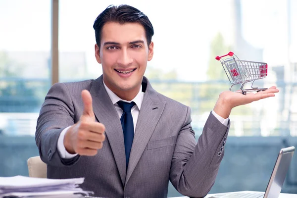 Empresario con carrito de compras en oficina —  Fotos de Stock