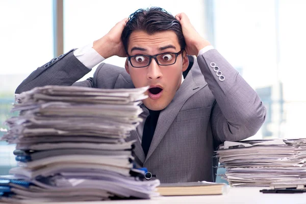 Bir yığın kağıt ile meşgul bir işadamı.