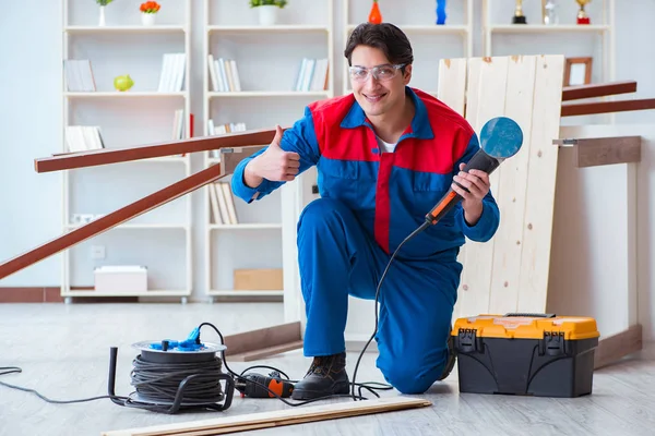 Jeune menuisier travaillant avec des planches en bois — Photo