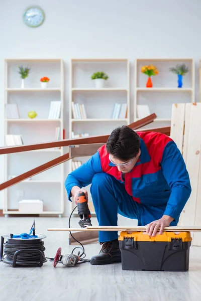 Genç marangoz ahşap kalaslarla çalışıyor.