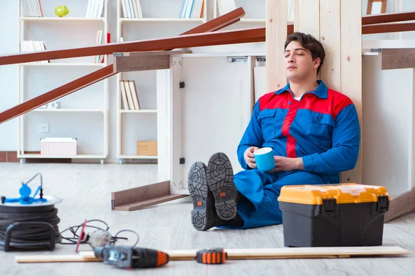 Genç marangoz ahşap kalaslarla çalışmaya ara veriyor.