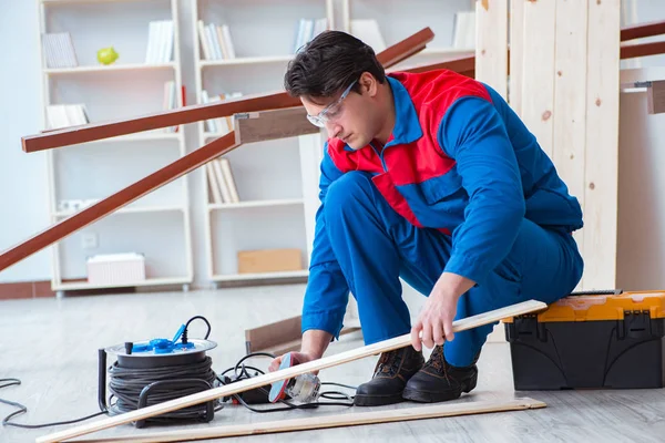 Genç marangoz ahşap kalaslarla çalışıyor.