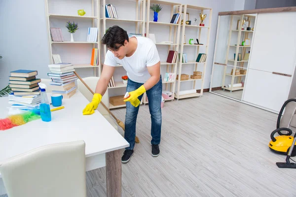 Adam evi temizliyor.