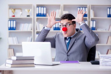 Ofiste çalışan palyaço işadamı.