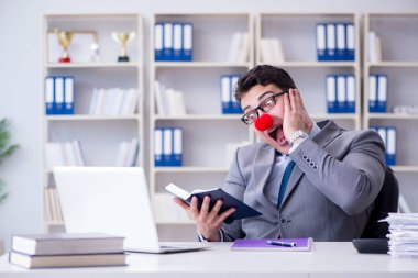 Ofiste çalışan palyaço işadamı.